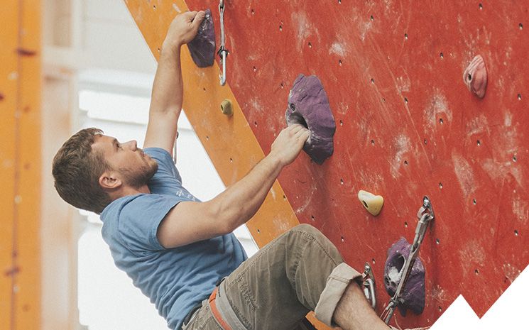 grimpeuse dans une salle d'escalade en valais lors d'un cours de coaching donné par lionel bonvin