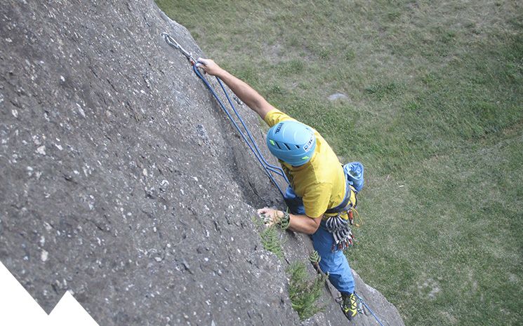 grimpeur mettant une dégaine à dorénaz en valais lors d'un cours d'escalade donné par lionel bonvin